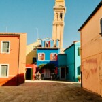 Colorful buildings and a leaning tower in burano.