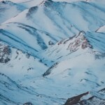 Snow-covered mountains against a blue sky.